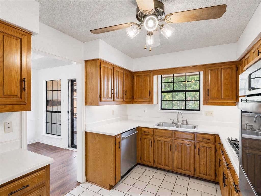 219 N Beltwoods Drive, DeSoto, TX 75115 Kitchen featuring wood cabinetry, white countertops, a double basin sink, and tile flooring