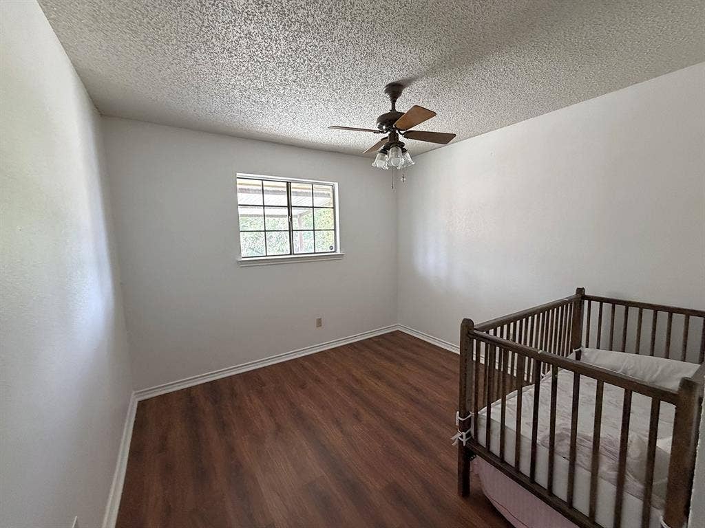 219 N Beltwoods Drive, DeSoto, TX 75115 Wood-finish flooring, white painted walls, window with gridded panes, and a ceiling fan with light fixture