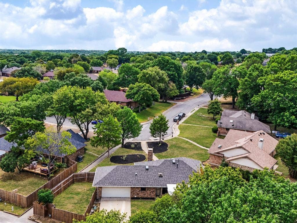 219 N Beltwoods Drive, DeSoto, TX 75115 Neighborhood with mature trees, paved streets, and residential properties featuring brick exteriors and shingle roofs