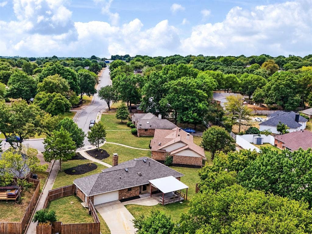 219 N Beltwoods Drive, DeSoto, TX 75115 Brick exterior residence with an attached garage, covered patio, and fenced yard