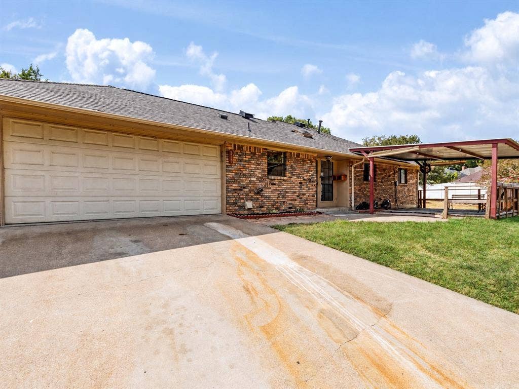 219 N Beltwoods Drive, DeSoto, TX 75115 Brick exterior with a covered patio, attached carport, concrete driveway, and a two-car garage