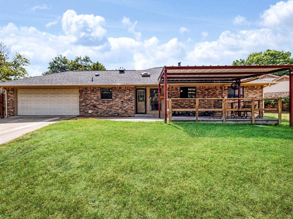219 N Beltwoods Drive, DeSoto, TX 75115 Brick exterior with an attached garage, covered patio, and a fenced yard