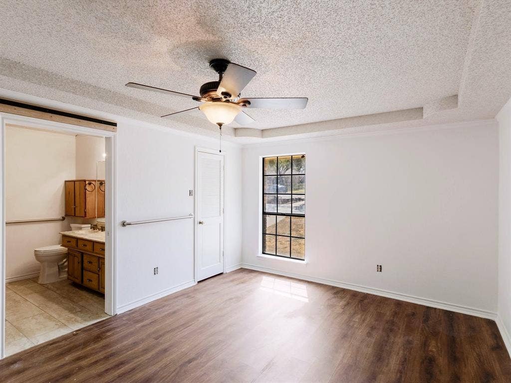 219 N Beltwoods Drive, DeSoto, TX 75115 Spacious room featuring wood-finish flooring, a ceiling fan with integrated lighting, and a multi-pane window