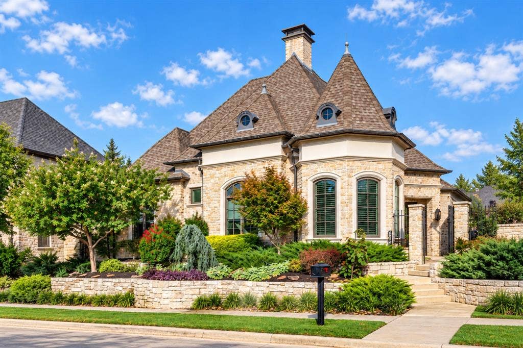 6816 Cousteau Court, Plano, TX 75024 Stone exterior with turret, arched windows, prominent chimney, and a multi-level roofline