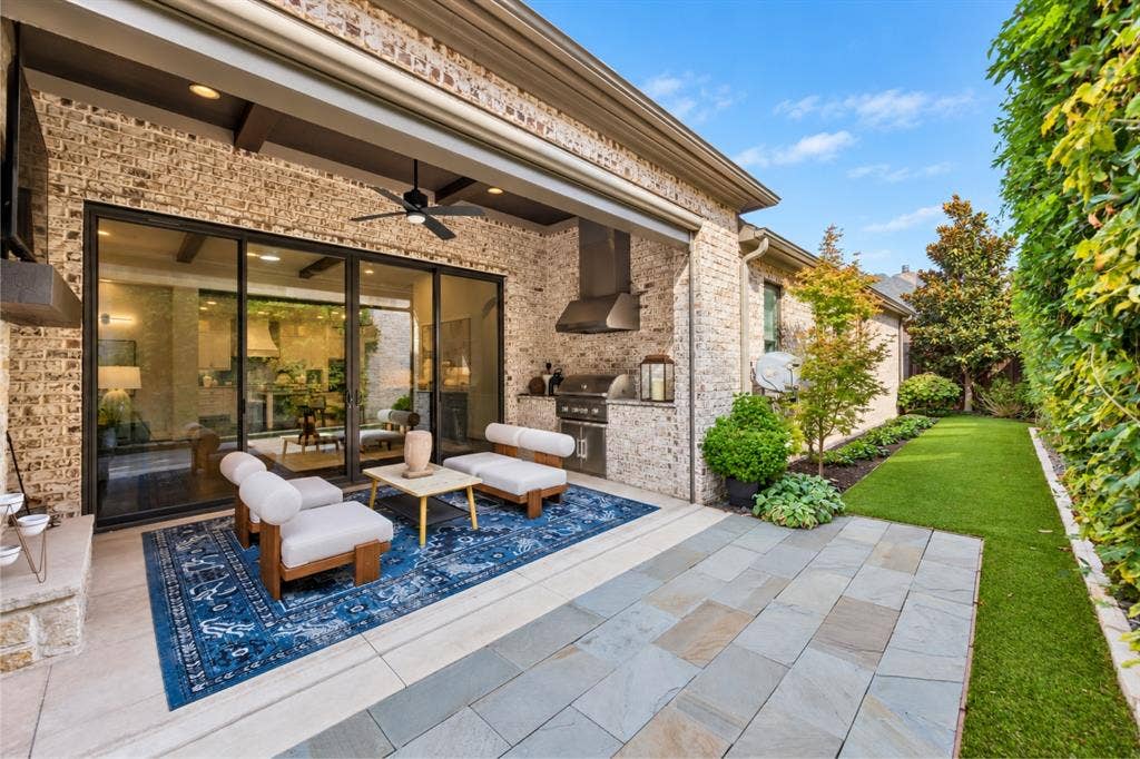 6816 Cousteau Court, Plano, TX 75024 Expansive patio featuring a built-in outdoor kitchen, ceiling fan, and large sliding glass doors