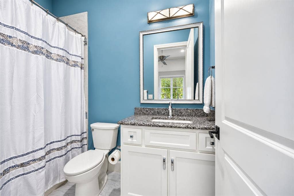 6816 Cousteau Court, Plano, TX 75024 White vanity with a stone countertop, an undermount sink, and a framed mirror above