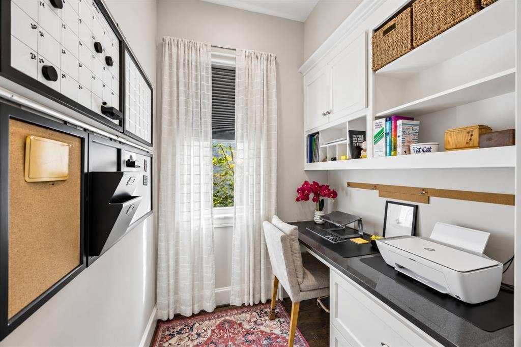 6816 Cousteau Court, Plano, TX 75024 Built-in desk with dark countertop, white cabinetry with upper shelving, and a large window with privacy blinds