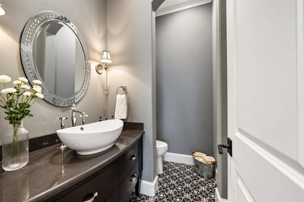 6816 Cousteau Court, Plano, TX 75024 Floating vanity with a vessel sink, chrome fixtures, and a decorative oval mirror