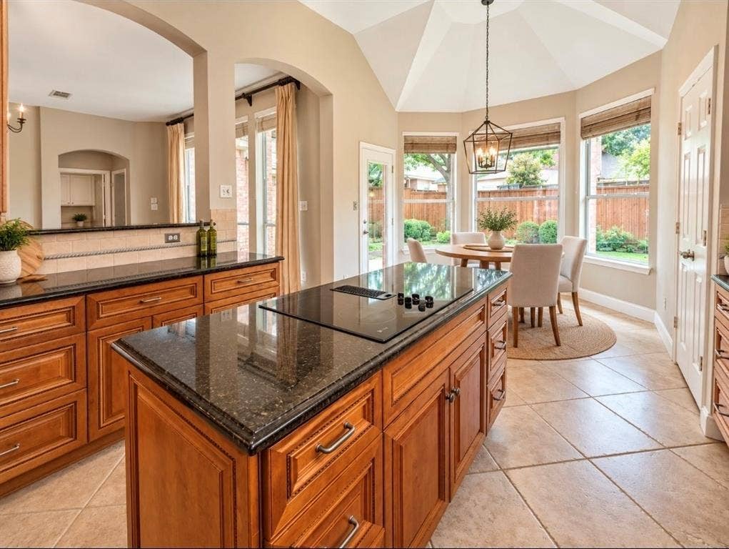 3708 Stockport Drive, Plano, TX 75025 Kitchen featuring wood-finish cabinetry, dark countertops, a built-in cooktop, and tile flooring