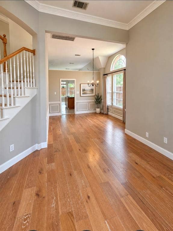 3708 Stockport Drive, Plano, TX 75025 Wood-finish flooring throughout, white crown molding, and a vaulted ceiling with an arched window