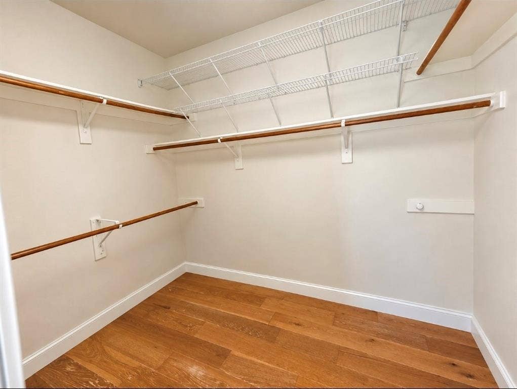 3708 Stockport Drive, Plano, TX 75025 Walk-in closet with wood-finish flooring, multiple hanging rods, and wire shelving
