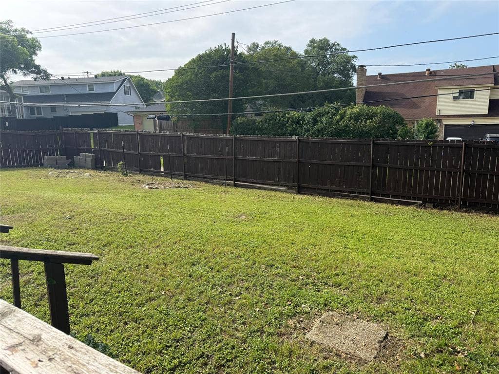 Expansive rear yard featuring a wood privacy fence and grassy area