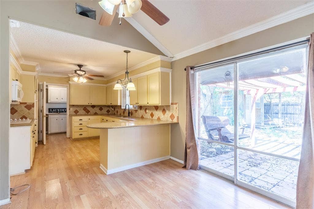 Kitchen featuring light-toned cabinetry, tile backsplash, and wood-finish flooring
