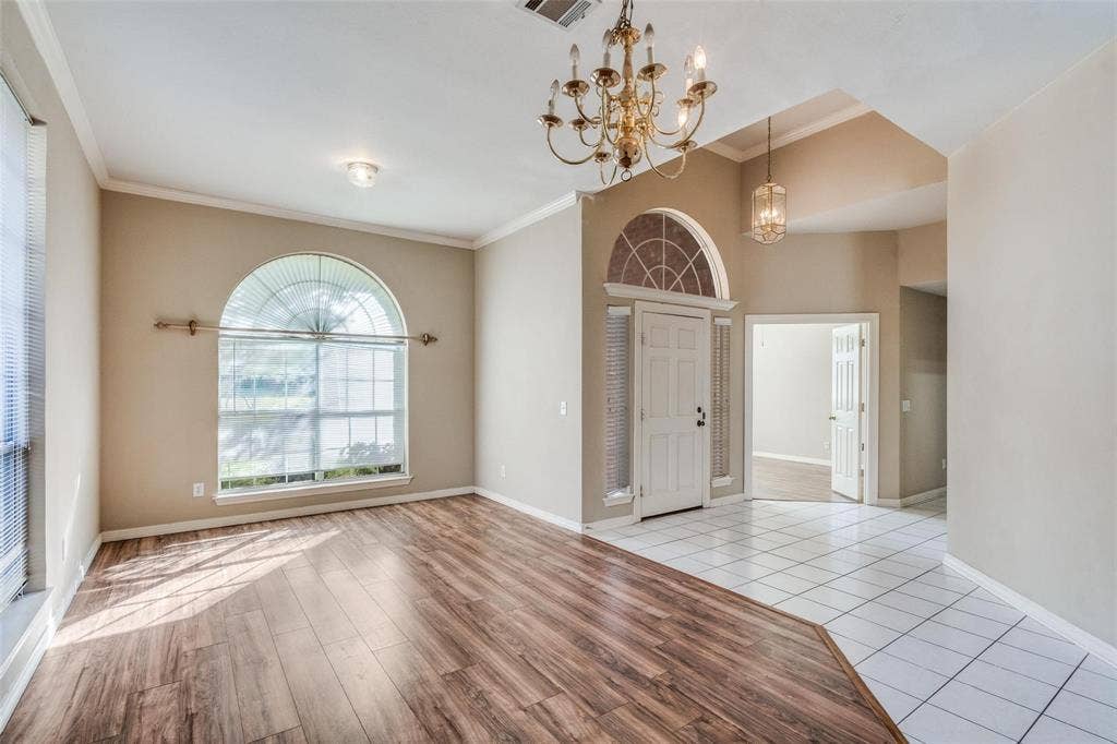 2305 Pittner Lane, Plano, TX 75025 Arched window with decorative trim, wood-finish flooring, tiled entry, tray ceiling, and a traditional chandelier