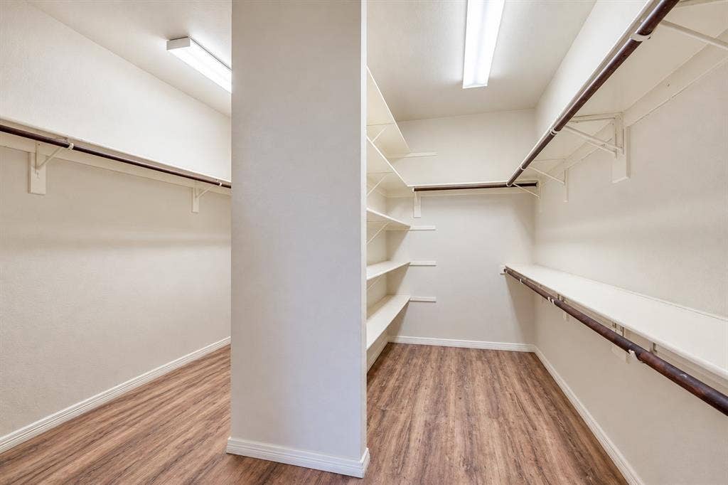 2305 Pittner Lane, Plano, TX 75025 Walk-in closet featuring wood-finish flooring, built-in shelving, and multiple hanging rods