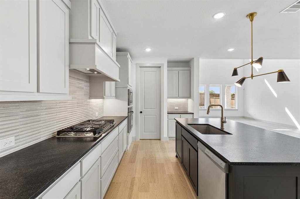 2624 Radiant Way, Celina, TX 75009 Beautiful two tone cabinetry, gorgeous countertops and classic backsplash effortlessly pair with contemporary stainless steel to create a dream ktchen for the ages!