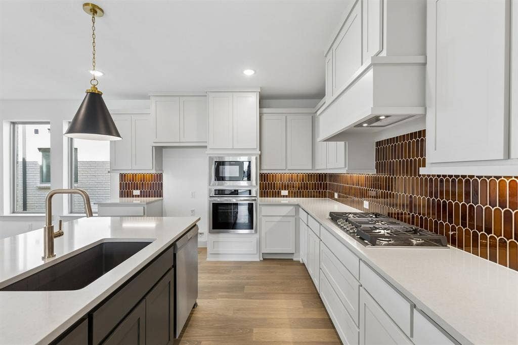 2612 Radiant Way, Celina, TX 75009 Beautiful two tone cabinetry, gorgeous countertops and striking backsplash effortlessly pair with contemporary stainless steel to create a classically styled dream kitchen!