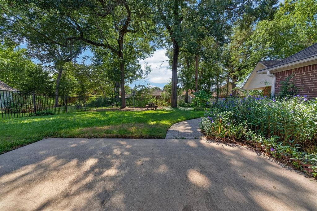 202 Northcreek Drive, Chandler, TX 75758 Taken from the Back Patio out over the Backyard. Walkway to Workshop, This area is where the iron fencing is not on the actual property line on what would be the West side. (Left side when looking out from the patio)