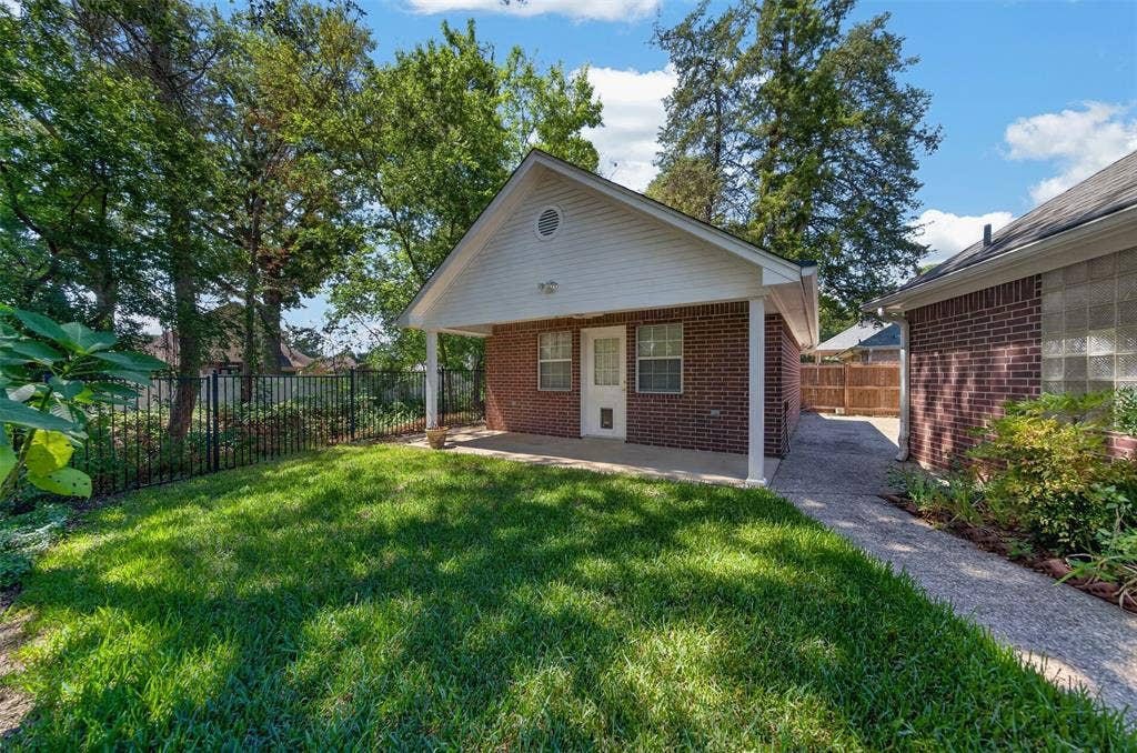 202 Northcreek Drive, Chandler, TX 75758 Workshop with Another View of the Back Yard that overlooks the Creek. You can also see the walkway that leads to the workshop and the area that can be used for extra parking or an RV