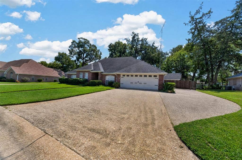 202 Northcreek Drive, Chandler, TX 75758 View of the Front showing the extra parking area and entrance to the backyard where you could park an RV between the home and workshop. There is a large gate at entrance.
