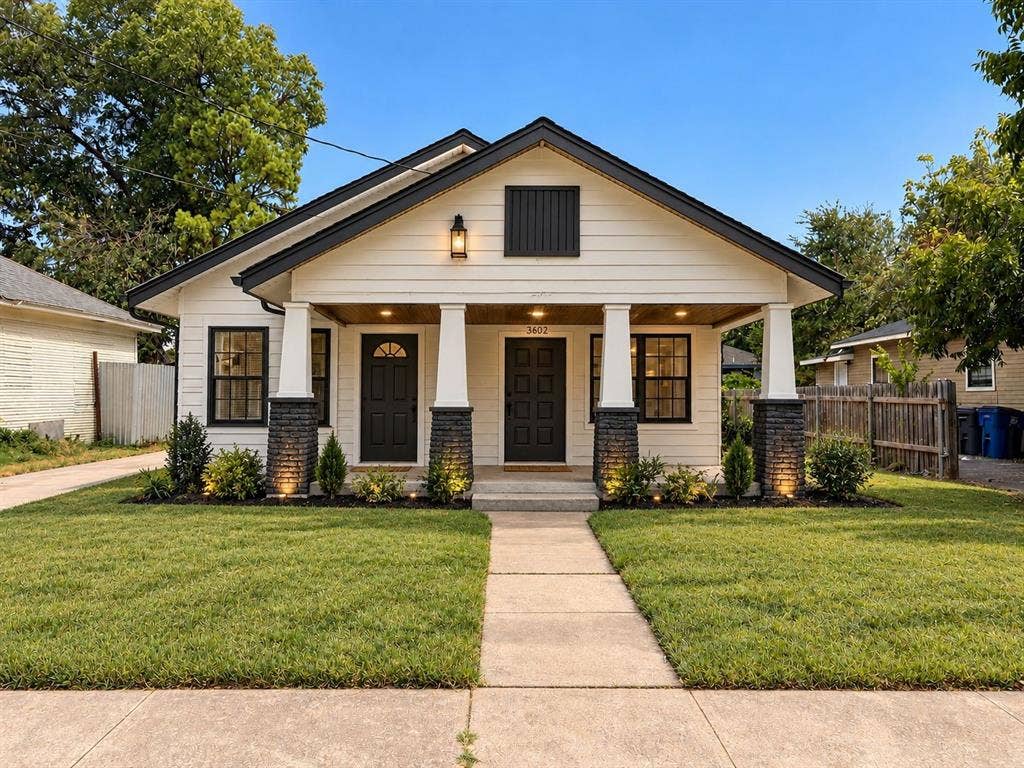 3602 Dunbar Street, Dallas, TX 75215 White horizontal siding exterior with black trim and a covered front porch featuring two entries