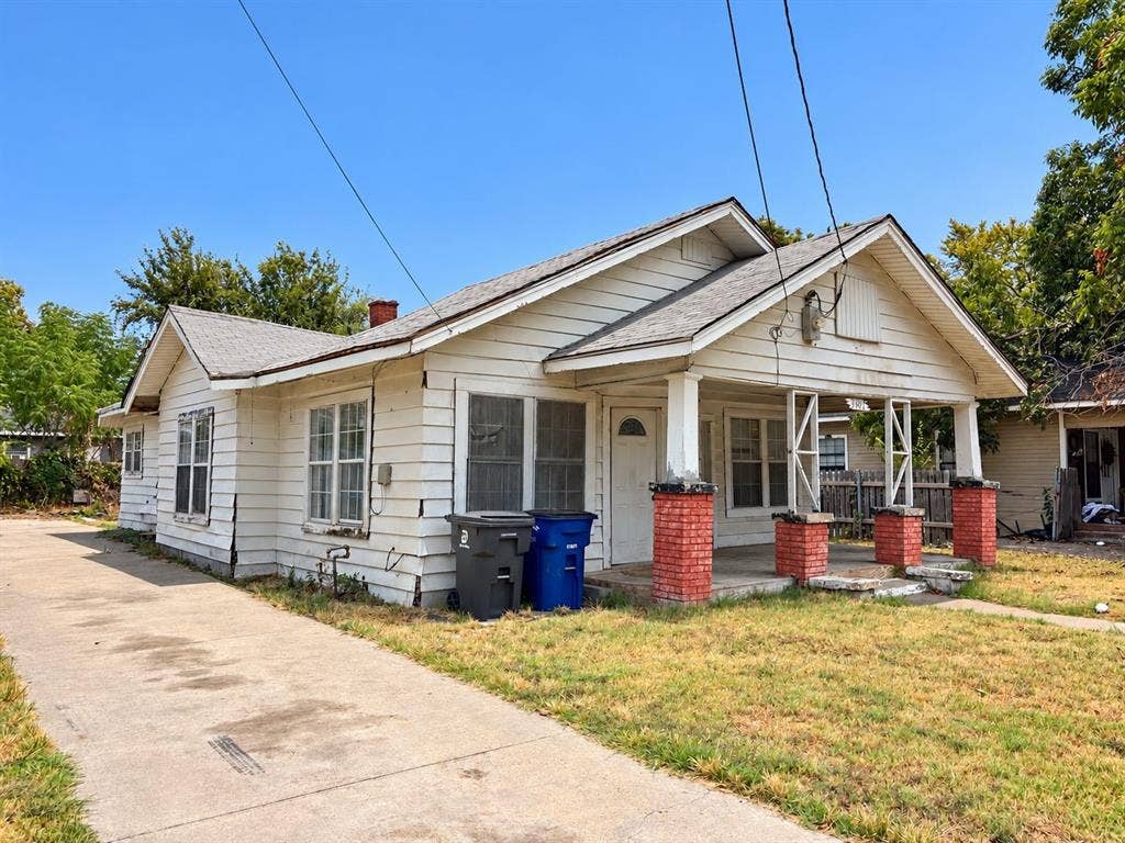 3602 Dunbar Street, Dallas, TX 75215 Single-story residence featuring a covered front porch with brick pillars, white siding, and a concrete driveway