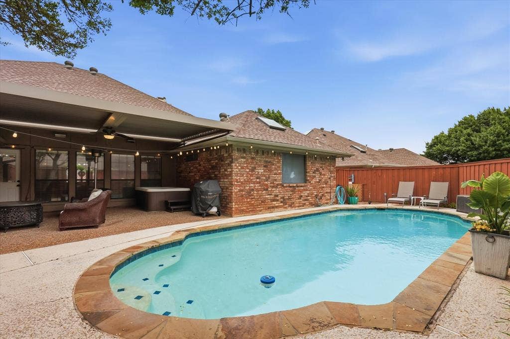 1516 Glastonbury Drive, Plano, TX 75075 Inviting backyard featuring a swimming pool with stone coping, a covered patio, a hot tub, and a privacy fence
