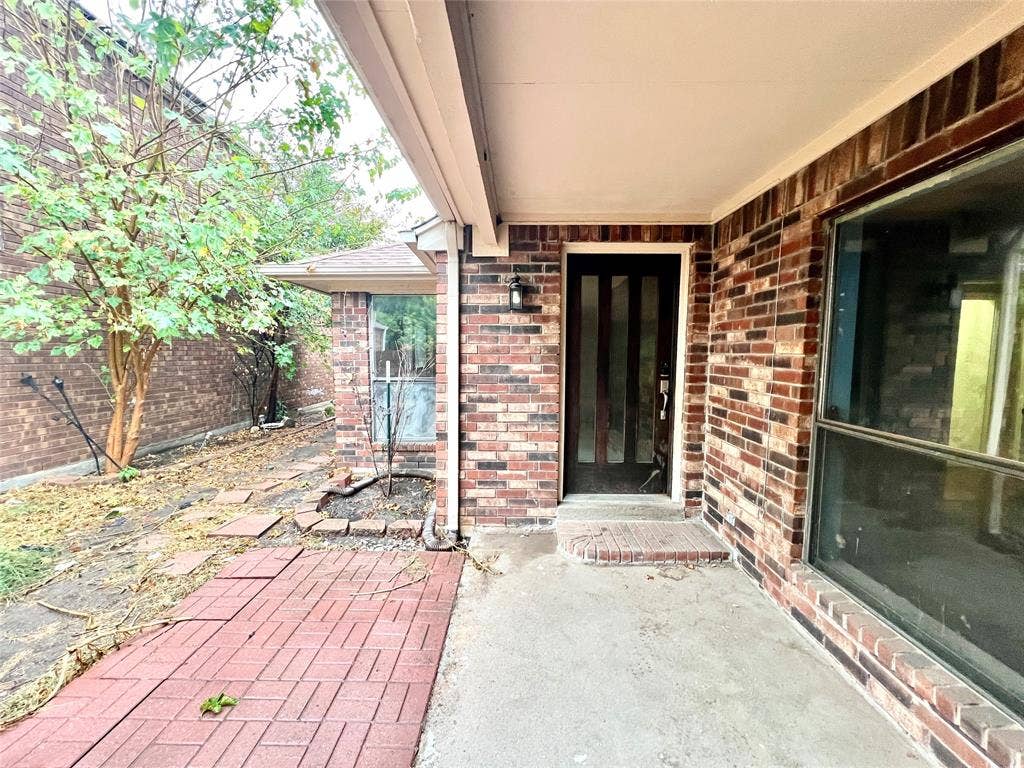 3912 Denham Way, Plano, TX 75023 Brick exterior with a covered entry, a red paver walkway, and a multi-pane entry door