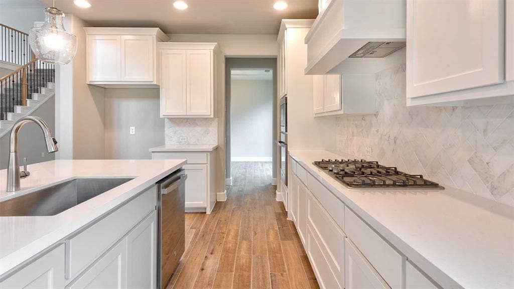 4237 Capstone Road, Midlothian, TX 76065 Kitchen featuring white shaker cabinetry, light-toned countertops, a stainless steel sink, wood-finish flooring, and a gas cooktop with a built-in ventilation hood