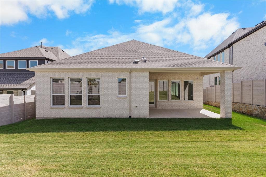 4524 Sunfish Lane, McKinney, TX 75071 White brick exterior with a covered patio, multiple windows, and a shingle roof