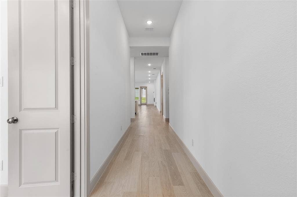 4524 Sunfish Lane, McKinney, TX 75071 Light wood-finish flooring extending through the hallway