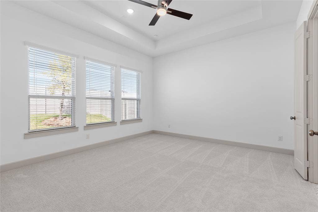 4524 Sunfish Lane, McKinney, TX 75071 Tray ceiling with a ceiling fan, three windows with blinds, and light-toned carpeting