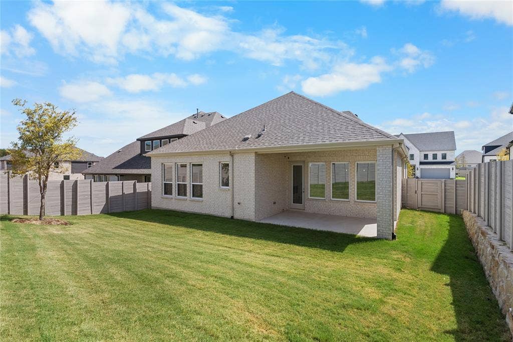 4524 Sunfish Lane, McKinney, TX 75071 Expansive backyard featuring a large concrete patio, mature tree, and privacy fencing