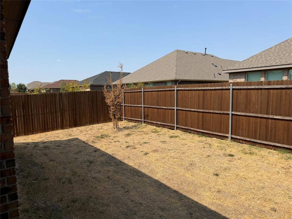 5213 Meadow Lane, Krum, TX 76249 Enclosed backyard featuring a wood privacy fence with metal posts
