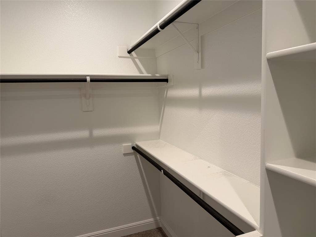 5213 Meadow Lane, Krum, TX 76249 Built-in shelving, white walls, black metal hanging rods, and carpet flooring