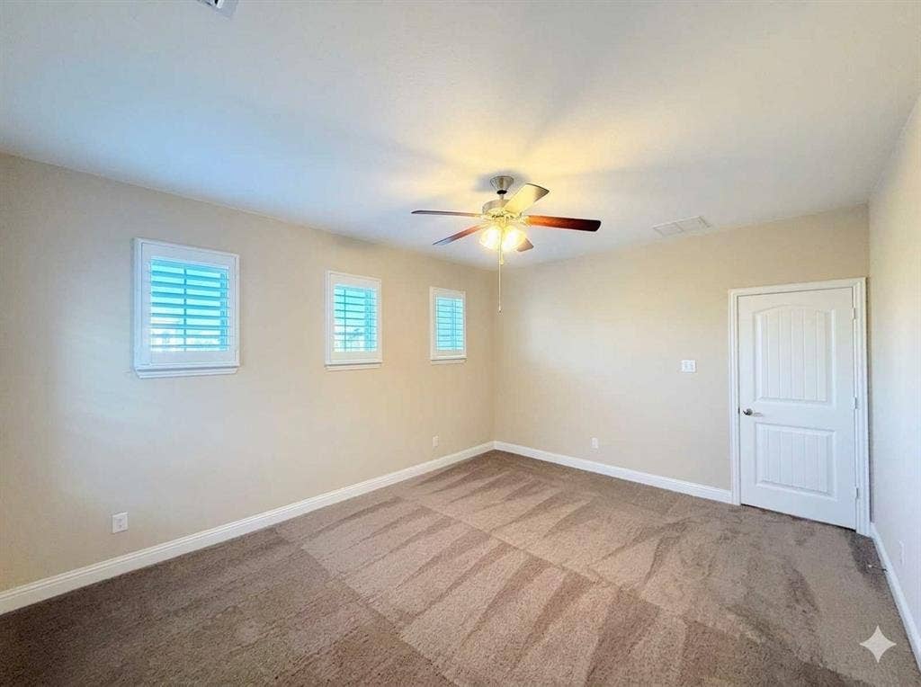 5917 Trantina Lane, Frisco, TX 75035 Carpeted flooring, three windows with white plantation shutters, white paneled door, and a ceiling fan with integrated lighting