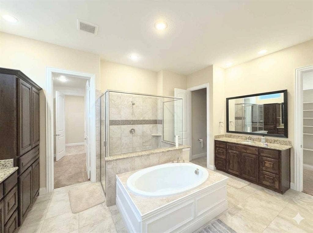 5917 Trantina Lane, Frisco, TX 75035 Soaking tub with tiled surround, separate glass-enclosed shower, dual vanity with undermount sink, dark wood-finish cabinetry, and recessed lighting