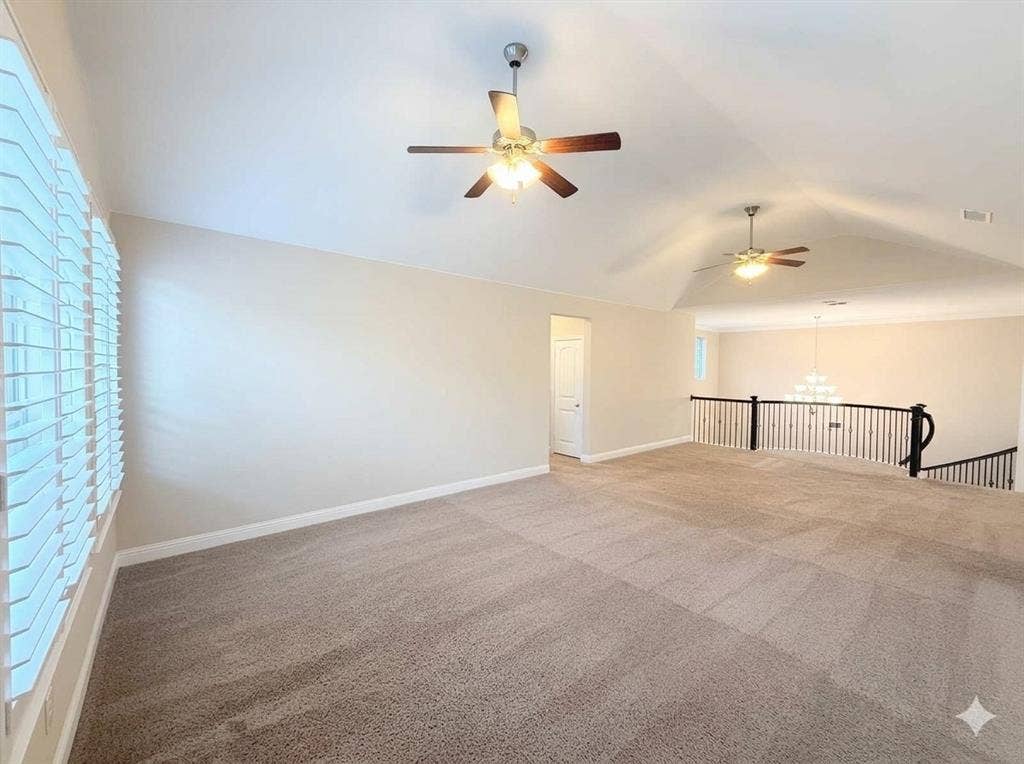 5917 Trantina Lane, Frisco, TX 75035 Vaulted ceiling with dual ceiling fans, neutral carpeting, and a white balustrade with dark wood accents overlooking a lower level