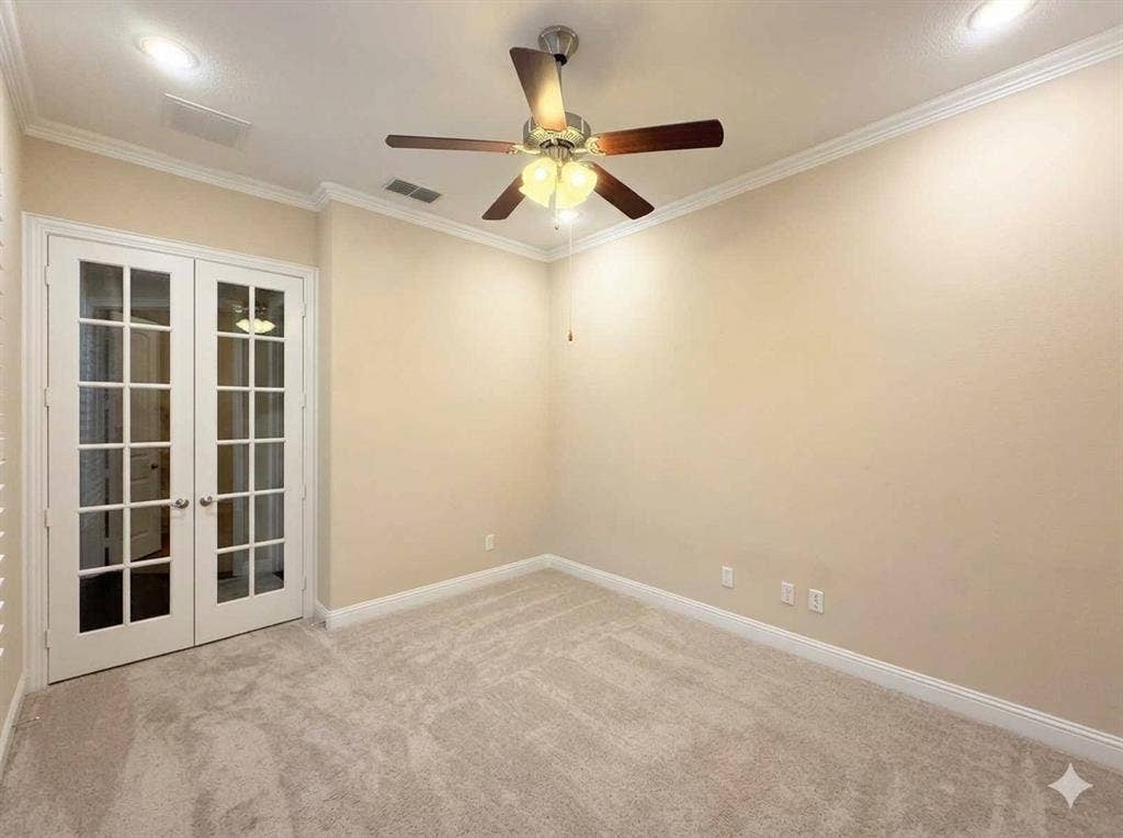 5917 Trantina Lane, Frisco, TX 75035 Neutral tone wall paint, light-colored carpeting, white French doors with glass panes, crown molding, and a ceiling fan with integrated lighting