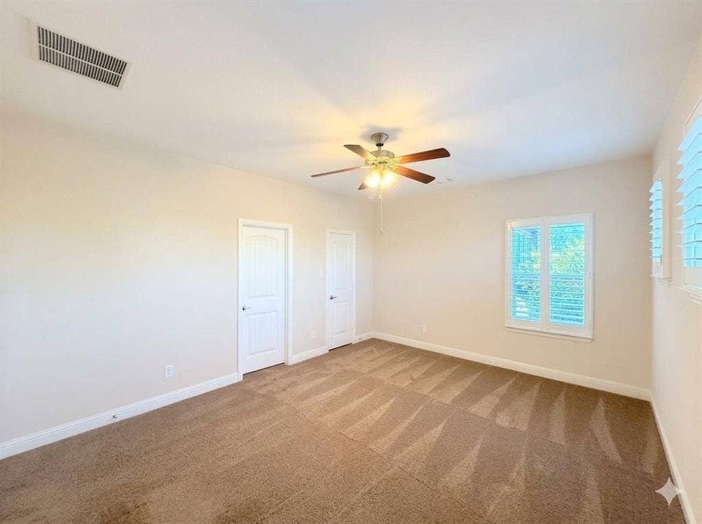 5917 Trantina Lane, Frisco, TX 75035 Neutral-toned walls, two panel doors, window with louvered shutters, ceiling fan with integrated lighting, and carpet flooring