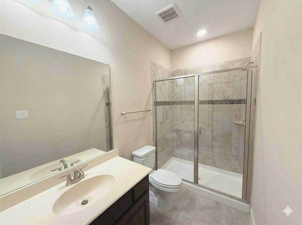 5917 Trantina Lane, Frisco, TX 75035 Vanity with integrated sink and chrome faucet, large frameless mirror, and overhead vanity lighting