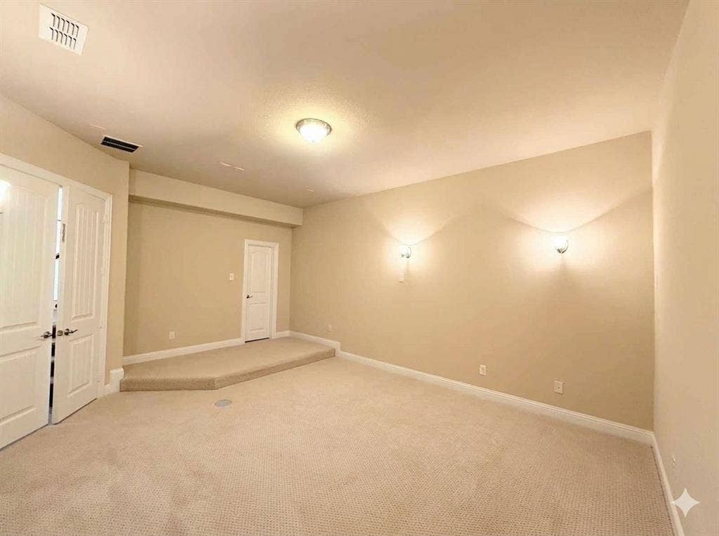 5917 Trantina Lane, Frisco, TX 75035 Carpeted room featuring a recessed ceiling light, two wall sconces, a raised platform, and white panel doors