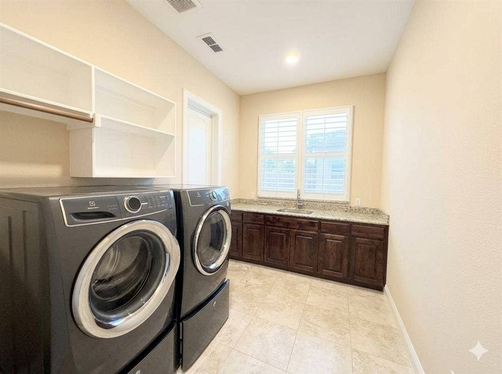 5917 Trantina Lane, Frisco, TX 75035 Laundry room featuring tiled flooring, built-in cabinetry with a countertop and sink, window with plantation shutters, and overhead shelving