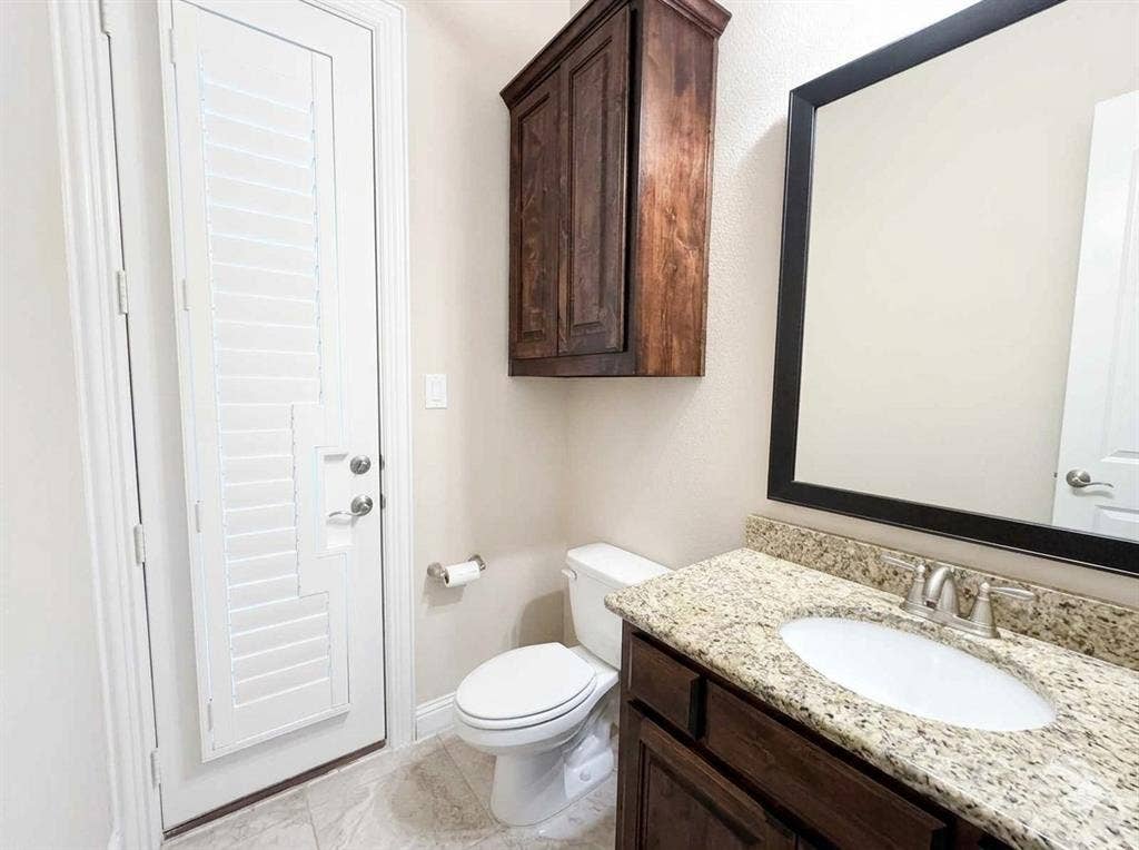 5917 Trantina Lane, Frisco, TX 75035 Vanity with a granite countertop, undermount sink, and brushed nickel faucet