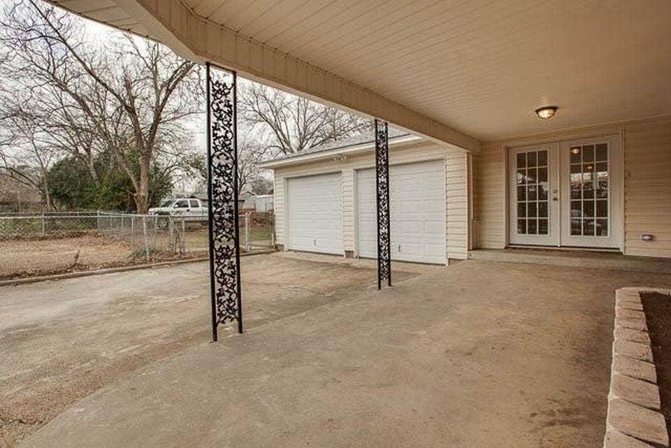 Covered concrete patio featuring decorative metal columns and built-in overhead lighting