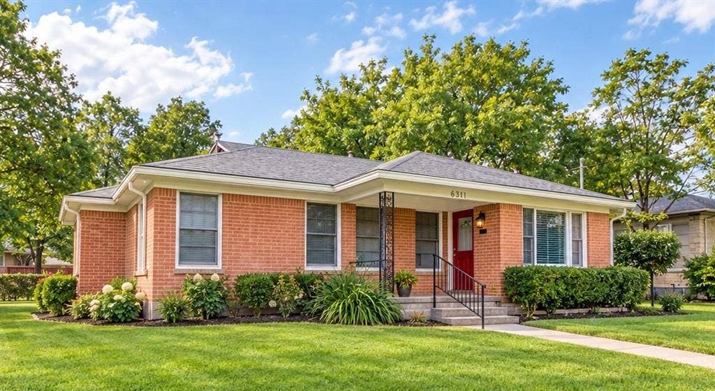 Brick exterior with a covered front entry and a red front door