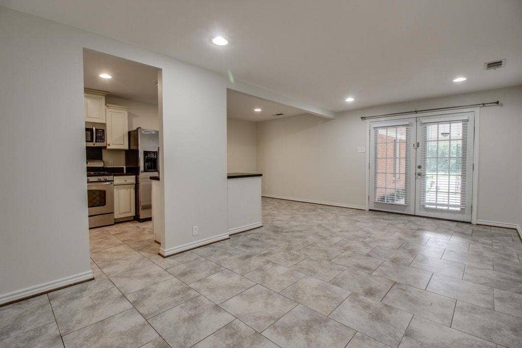 Tiled flooring throughout, recessed lighting, and double glass doors with interior blinds