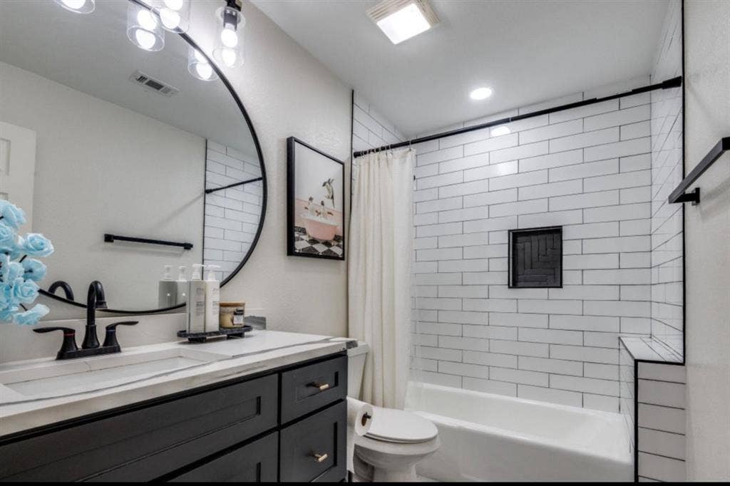 171 Wildwood Drive, DeSoto, TX 75115 Updated secondary bathroom featuring marble-look flooring, modern vanity, and tiled tub surround.