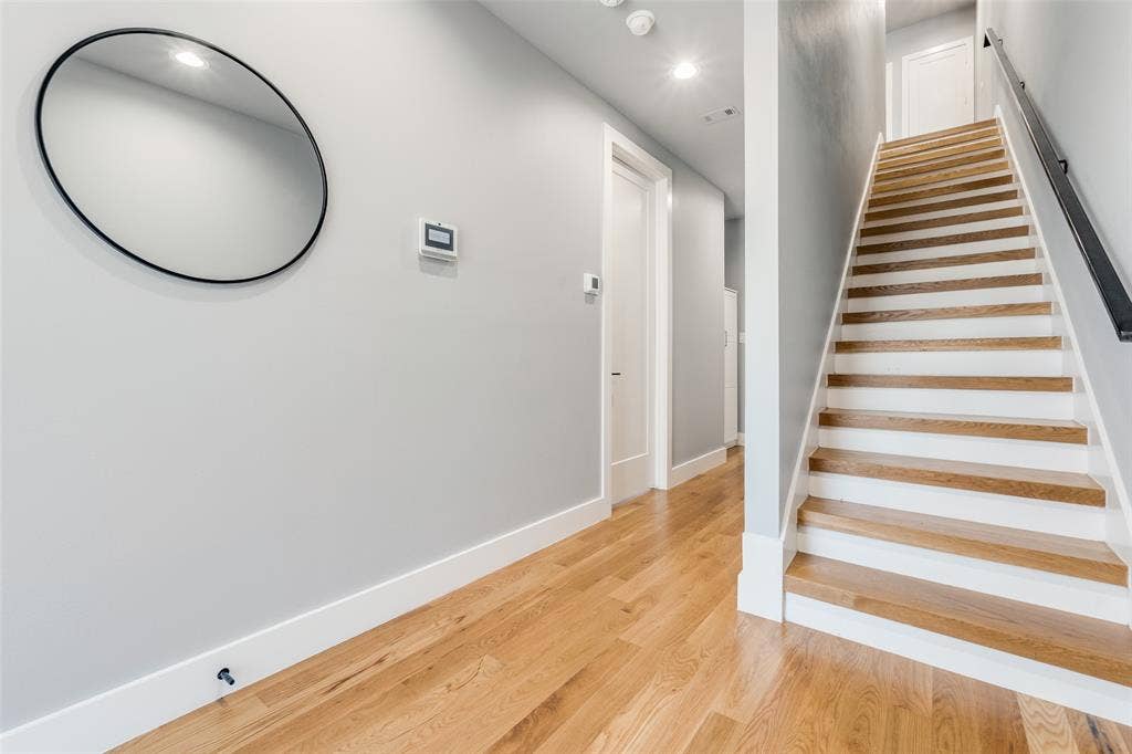 805 Pavillion Street, #103, Dallas, TX 75204 Hardwood flooring, painted walls, white trim, recessed lighting, and a staircase with a dark handrail