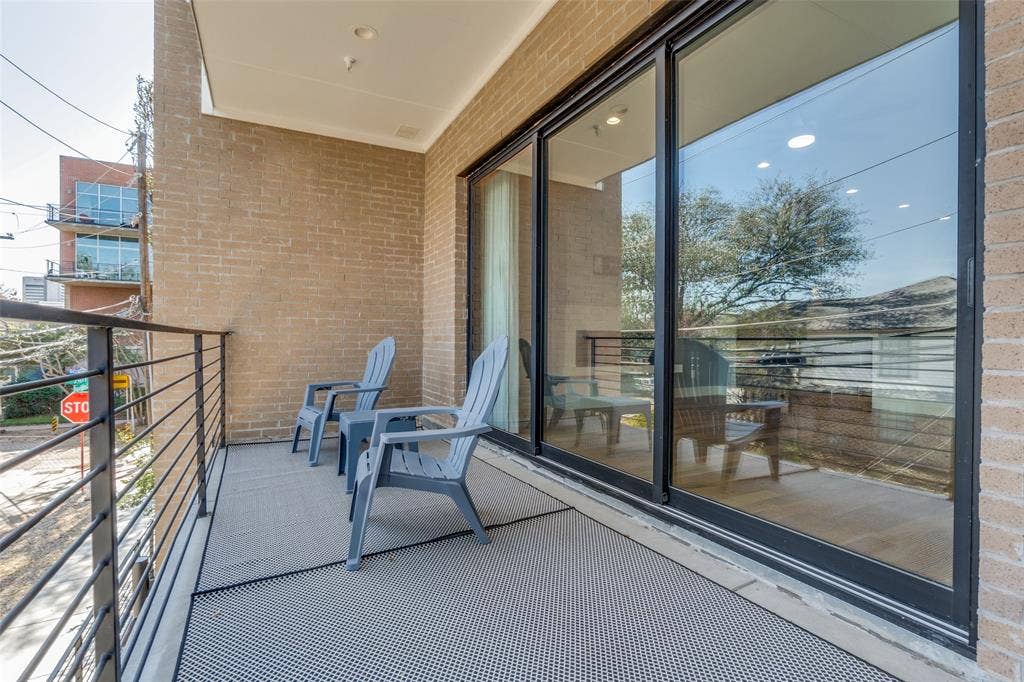 805 Pavillion Street, #103, Dallas, TX 75204 Balcony featuring brick exterior, black metal railing, and large sliding glass doors
